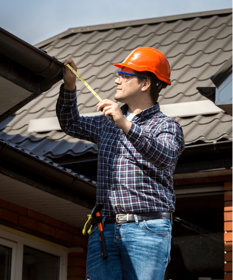 A roofer measuring a roof